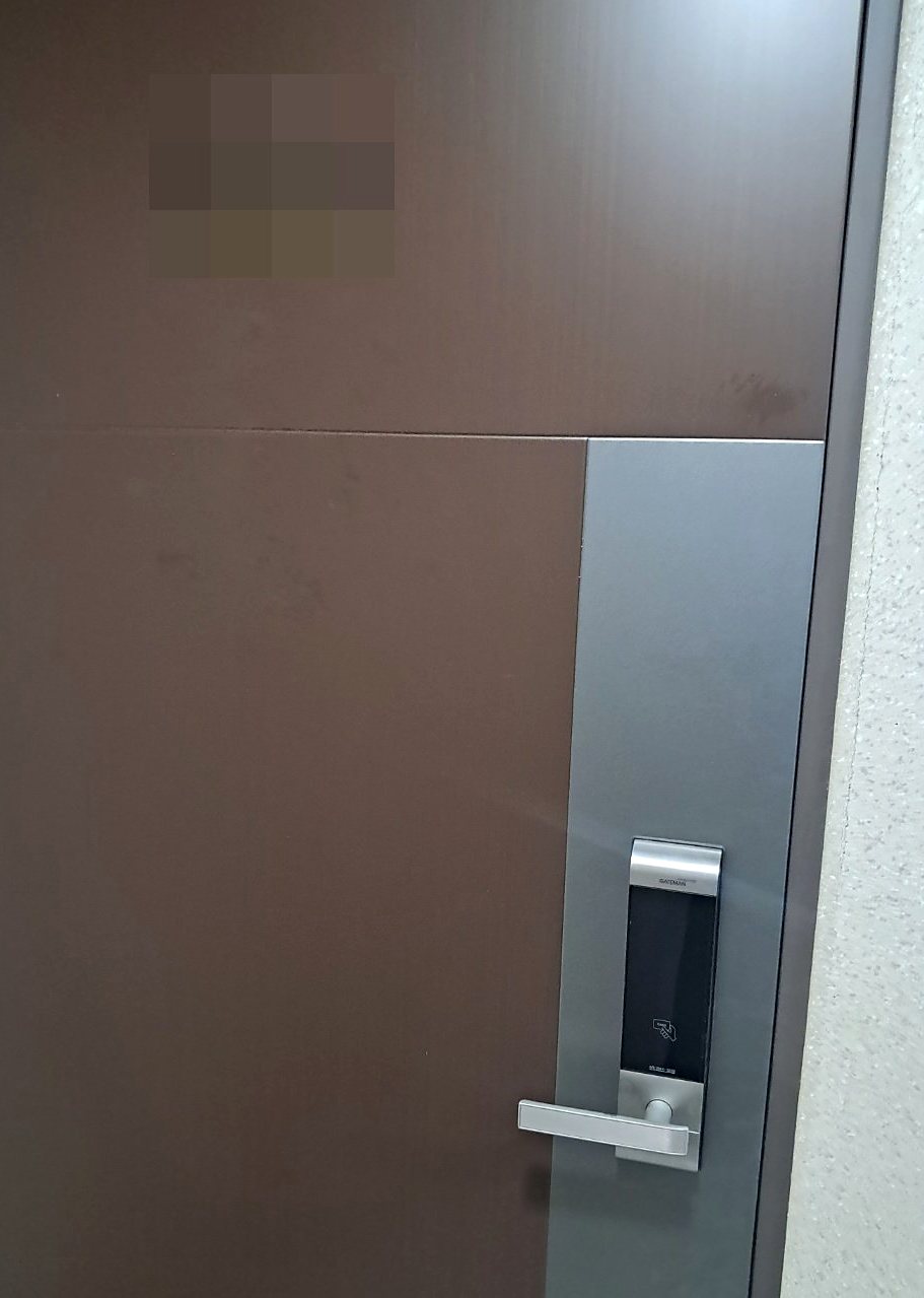 부평구 산곡2동 출장 — 넓은 갈색 문 오른쪽 은색 판 위에 단 작은 도어락과 카드 표시, 은색 레버